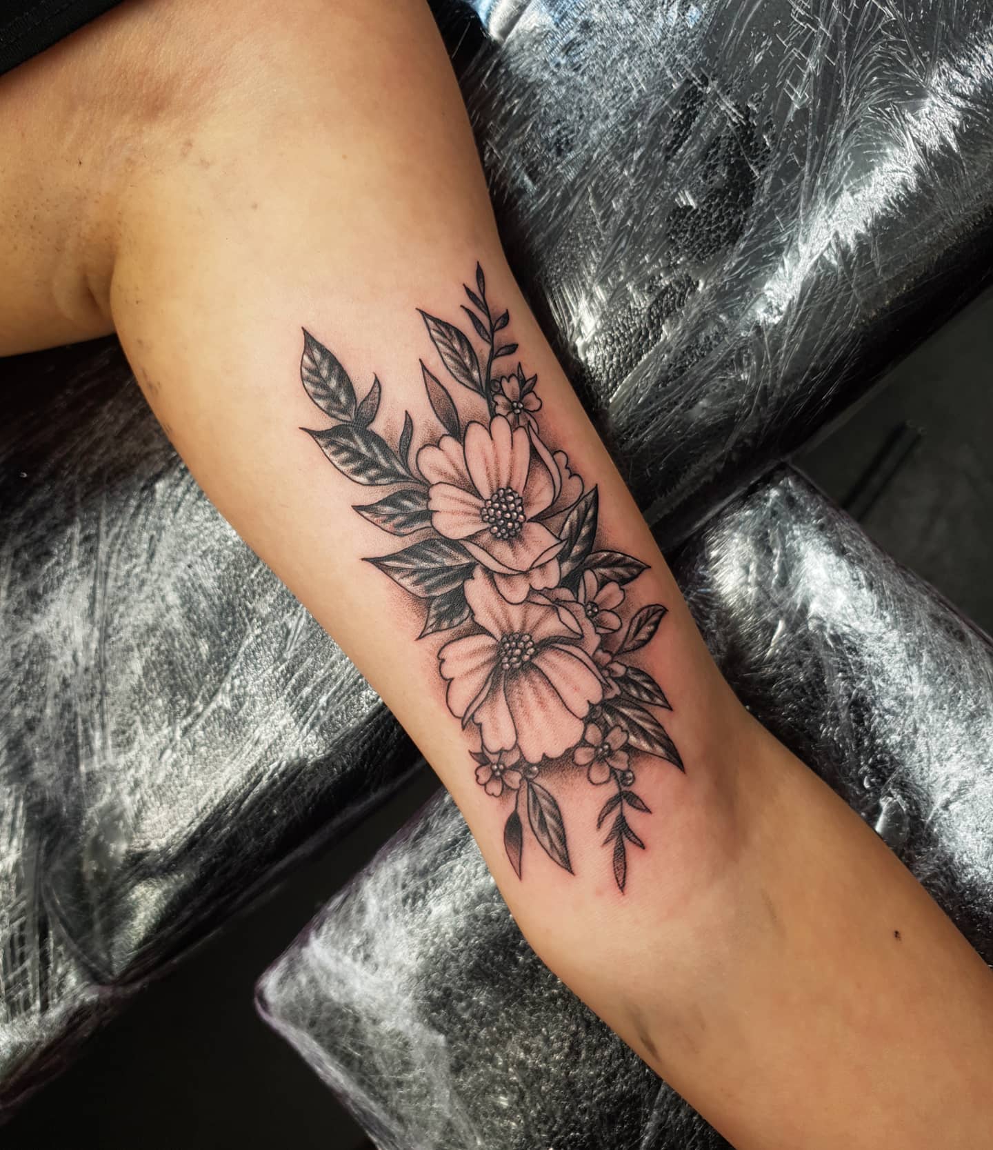 Flower head woman cover up tattoo on the inner arm